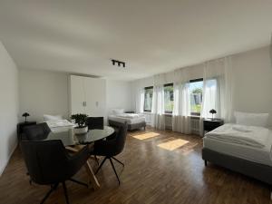 a bedroom with a table and a bed and a dining room at Ferienwohnung nähe Montabaur A3 in Großholbach