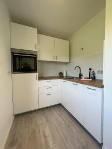 uma cozinha com armários brancos e um lavatório em Ferienwohnung nähe Montabaur A3 