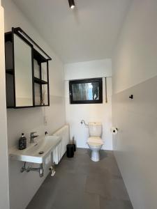 a white bathroom with a toilet and a sink at Ferienwohnung nähe Montabaur A3 in Großholbach +5 photos
