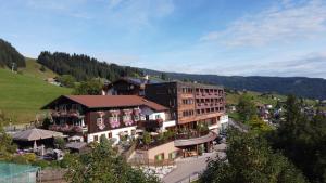 un hôtel situé dans une vallée avec une colline verdoyante dans l'établissement Familotel Alphotel, à Hirschegg