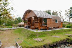 a large wooden house with a metal roof at ชีวาวิลล์ ฟาร์มสเตย์ - Cheewavill farmstay in Ban Ko