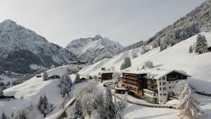 ein Hotel in den schneebedeckten Bergen in der Unterkunft Familotel Alphotel in Hirschegg