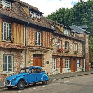 an old blue car parked in front of a building at Le Petit Nicolas in Les Andelys