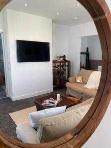 - un salon avec un canapé et une télévision murale dans l'établissement The Santiago Suite - sleeps 10, à Southport
