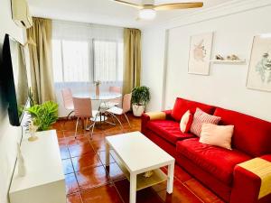 a living room with a red couch and a table at Welcome Málaga in Málaga