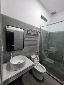 a bathroom with a toilet and a sink and a shower at Cay Phuong Guesthouse in Mui Ne