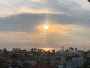 una vista de la puesta de sol desde una ciudad en Apartamento Vista Mar en Peruíbe