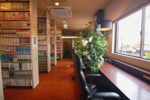 a library with chairs and bookshelves at Red Submarine in Kure