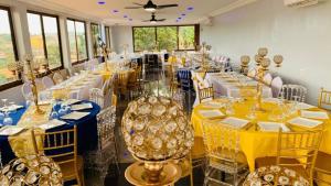a room filled with tables with yellow and blue table settings at L'Integrale in Yaoundé