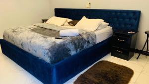 a large blue bed in a bedroom with a blue headboard at L'Integrale in Yaoundé