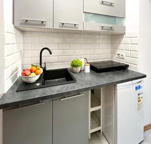 a kitchen with a sink and a bowl of fruit at K22 Andersa 12 m Ratusz Arsenał in Warsaw