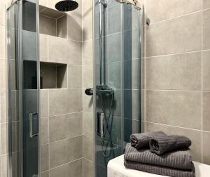 a shower with a glass door next to a toilet at K22 Andersa 12 m Ratusz Arsenał in Warsaw