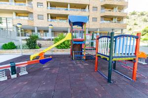 a playground in front of a building at Penthouse sea view, pool, terrace, 2 bedrooms in Cala de Finestrat