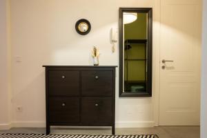 a bedroom with a dresser and a mirror next to a door at Fully renovated 2-room central apartment in Vienna