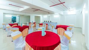 a room with red and white tables and chairs at Treebo Trend Landmark in Pune