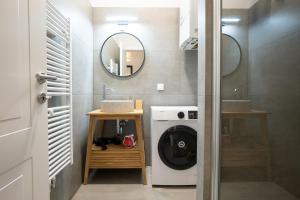 a bathroom with a washing machine and a mirror at Fully renovated 2-room central apartment in Vienna