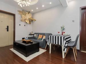 ein Wohnzimmer mit einem Sofa und einem Tisch in der Unterkunft Annie Apartment - only 120 metres from Metro Line 2 Exit B of Chuanxingulou in Kunming