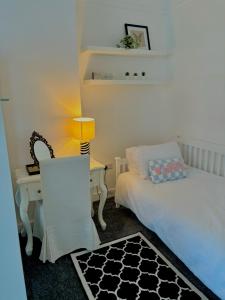 um quarto com uma cama e uma secretária com um candeeiro em The Santiago Suite - sleeps 10 em Southport