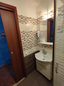 a bathroom with a sink and a toilet and a mirror at La Mensa Ponderaria in Tivoli