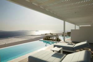 una piscina con sillas y vistas al océano en San Marco Hotel and Villas en Houlakia