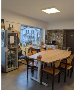 cocina con mesa, sillas y nevera en Le Fagotin - Youth hostel en Stoumont
