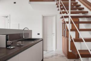 une cuisine avec un escalier en bois à côté d'un comptoir dans l'établissement Palazzo Sovrana, à Palerme