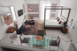 un soggiorno con letto e tavolo in vetro di Palazzo Sovrana a Palermo