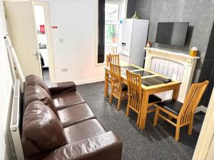 ein Wohnzimmer mit einem Sofa und einem Tisch sowie eine Küche in der Unterkunft Three Rose Manor At Warwick Road Near Birmingham Airport in Birmingham