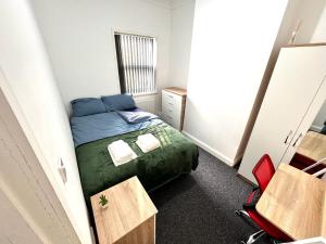 ein kleines Schlafzimmer mit einem Bett und einem Schreibtisch in der Unterkunft Three Rose Manor At Warwick Road Near Birmingham Airport in Birmingham