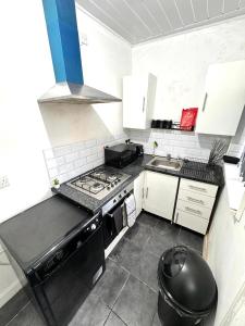 una pequeña cocina con fogones y fregadero en Three Rose Manor At Warwick Road Near Birmingham Airport en Birmingham