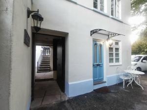 a white building with a blue door and a table at Castle Retreats Nest & Crown in Torquay