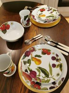 a wooden table with plates and cups and utensils at Castle Retreats Nest & Crown in Torquay