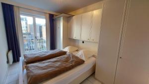 Kleines Zimmer mit einem Bett und einem Fenster in der Unterkunft Zeedijk Koksijde in Koksijde