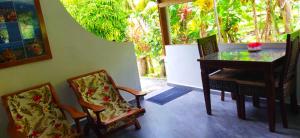 a dining room with a table and two chairs at Dan Zoranz Self Catering Guest House in La Digue