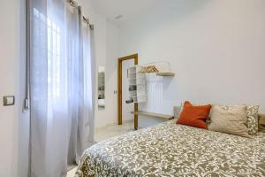 een witte slaapkamer met een bed en een raam bij Cozy Getaway in Madrid in Madrid