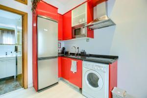 een keuken met rode muren en een wasmachine bij Cozy Getaway in Madrid in Madrid