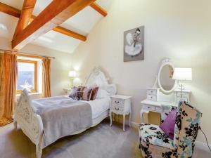 a bedroom with a bed and a chair and a mirror at Rookery barn in the outskirts of darley in Harrogate