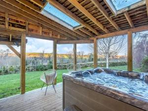a large hot tub in a patio with a view of a yard at Rookery barn in the outskirts of darley in Harrogate