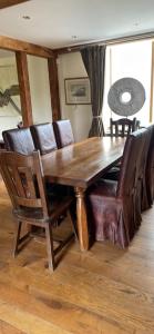 a wooden dining room table with leather chairs and a table at Rookery barn in the outskirts of darley in Harrogate