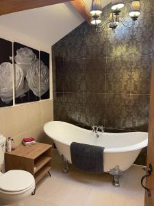 a bathroom with a tub and a toilet and a sink at Rookery barn in the outskirts of darley in Harrogate