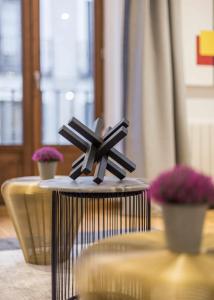 a black and white sculpture on a table with flowers at Luxury apartment in the center Gran Via Colon in Madrid