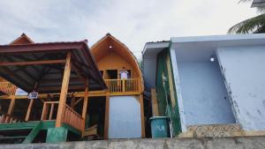 un homme debout sur le balcon d'une maison dans l'établissement Pondok Wisata Botu Barani, à Gorontalo