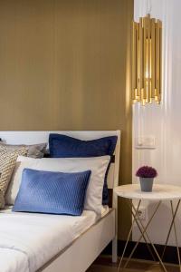 a bed with blue and white pillows and a side table at Luxury apartment in the center Gran Via Colon in Madrid