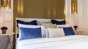 a bed with blue and white pillows on it at Luxury apartment in the center Gran Via Colon in Madrid