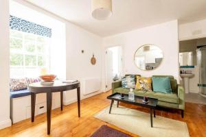 a living room with a green couch and a table at Central 2 Bedroom Apartment - South Street - St Andrews in St. Andrews