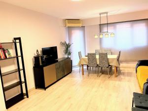 un soggiorno con tavolo, sedie e TV di Apartment Monfort a Valencia