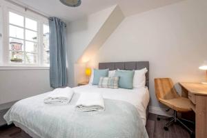 een slaapkamer met een bed met handdoeken erop bij Luxury Penthouse Apartment on South Street in St Andrews