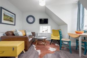 a living room with a couch and a table and chairs at Luxury Penthouse Apartment on South Street in St Andrews