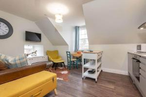 a living room with a couch and a table at Luxury Penthouse Apartment on South Street in St. Andrews