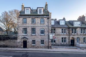 an old stone building on the corner of a street at Luxury Penthouse Apartment on South Street in St Andrews